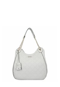 Borsa bianca con motivo trapuntato, rifiniture nere e dettagli in catena dorata. Presenta un'etichetta con logo e una forma rotonda e spaziosa.