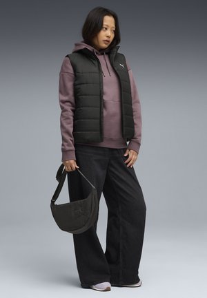 Veste noire rembourrée sur un sweat à capuche mauve, associée à un jean large foncé et à un petit sac à bandoulière noir. Comprend des chaussures de sport avec des accents violets.
