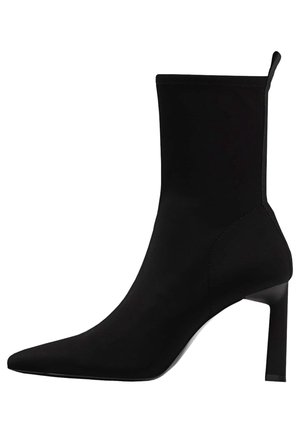Bottine noire à bout pointu avec un talon haut et fin et une tige en tissu élastique, dotée d'une languette à l'arrière.