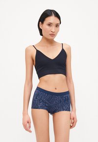 Tengerészkék pamut bralette v-nyakkivágással és vékony pántokkal, párosítva mintás tengerészkék boxer rövidnadrággal, amely hullámos textúrájú.