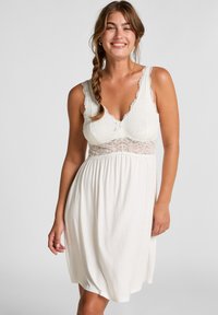 Pigiama da notte bianco realizzato in morbido tessuto, con dettagli in pizzo sul corpino e sulle spalline, e una vita arricciata per un fit rilassato.