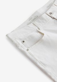 Weiße Denim-Skinny-Jeans mit silberner Hardware. Verfügt über eine kleine Vordertasche und sichtbare Nähte entlang der Säume. Etikett am Bund.