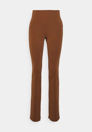 Bruine, hoog de taille zittende, slim-fit broek met rechte pijpen op een witte achtergrond.