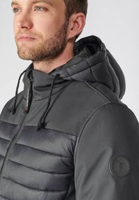 Grijze hoodie met een gevoerde voorkant, gladde mouwen, verstelbare trekkoorden en een badge-detail op de arm.