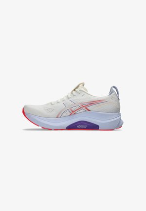 Chaussure de sport blanche avec un dessus respirant, des accents violets et une semelle texturée rouge. Les caractéristiques incluent un intermédiaire rembourré et des bandes réfléchissantes.