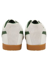 Sneaker in pelle bianca con accenti in suede verde e grigio, finitura texture e suola in gomma. La vista posteriore mostra una combinazione di colori bicolore.