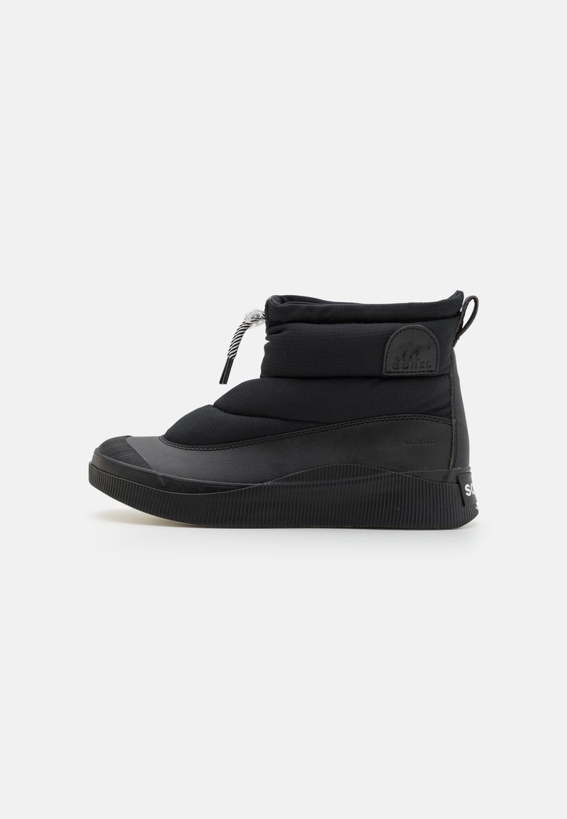 Botte isolante noire avec une tige matelassée, fermeture à élastique bungee et semelle en caoutchouc. Présente des accents texturés et un patch logo sur le côté.