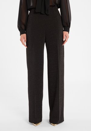 Zwarte broek met wijde pijpen gemaakt van een textiel met een subtiele glans. Heeft een hoge taille en is gecombineerd met metallic puntige schoenen.