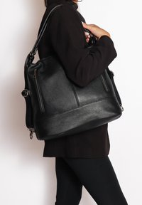 Borsa a tracolla in pelle nera con finitura testurizzata, doppi manici e tasche esterne con zip.