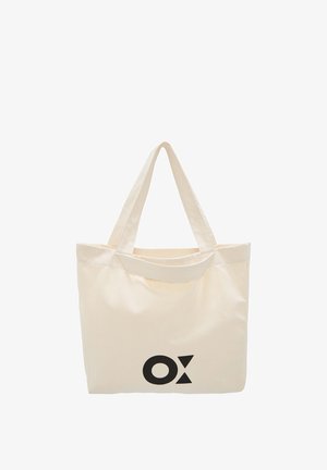 Canvas tote bag in off-white with two shoulder straps. Features a bold black "OX" logo on one side. Simple, rectangular shape.