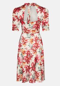 Blumenkleid aus weißem Stoff mit roten und rosa Blüten, puffierten kurzen Ärmeln und einem ausgeschnittenen Rücken mit einer Bindeschließe.