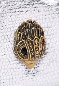 Zilveren metallic clutch met een gestructureerd slangenhuidontwerp, voorzien van een gedetailleerde vergulde sluiting versierd met zwarte en amberkleurige embellissementen.