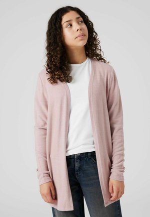 Cardigan rosa chiaro realizzato in un morbido tessuto texturizzato. Design con apertura frontale e maniche lunghe. Indossato sopra una t-shirt bianca e jeans.