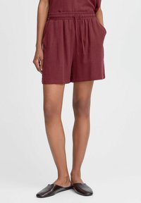 Shorts en lin bourgogne avec une taille élastique, un cordon de serrage et des poches latérales. Coupe décontractée, texture lisse et longueur au genou.