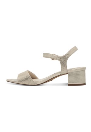Beige sandal featuring a textured leather upper, open toe, ankle strap with metal hardware, and a small block heel. Elegant and refined design.