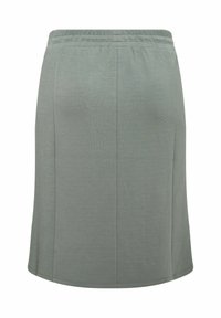 Fustă verde, până la genunchi, dintr-un material neted, cu un tiv elastic și o croială simplă, dreaptă, fără modele sau accente vizibile.