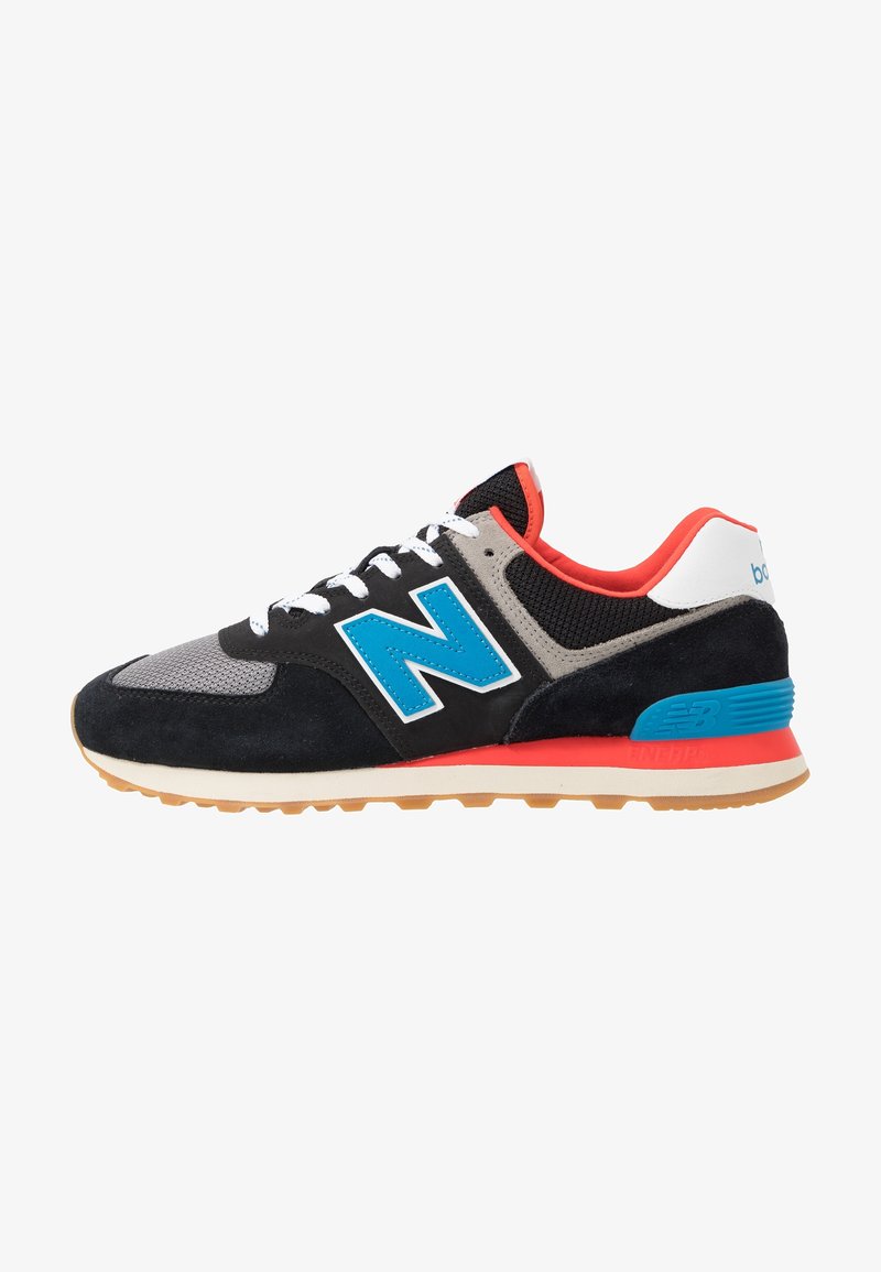 Vue latérale d'une chaussure de sport noire et grise avec un logo bleu, des lacets blancs, une doublure intérieure rouge et une semelle en caoutchouc.
