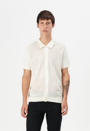 Strikket kortermet skjorte i off-white, med et mønster av fint nett og diamantformer, med klassisk krage og knappelukking foran.