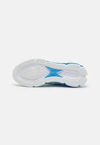 Semelle de chaussure de sport blanche et bleue avec motifs de grip texturés et rainures courbes pour la traction et la flexibilité.