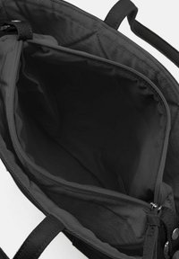 Sac fourre-tout noir avec un intérieur spacieux. Fabriqué en tissu doux avec des poignées robustes et une poche zippée pour un rangement sécurisé.