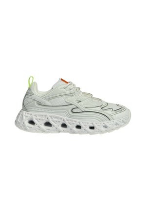 Baskets de sport blanches avec empeigne en mesh, motifs ondulés complexes et semelle épaisse à structure en treillis avec des trous d'air visibles.