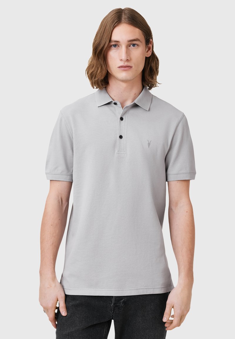 Lichtgrijze polo shirt van katoen, met een knoopsluiting van drie knopen, korte mouwen en een klein geborduurd logo op de borst.