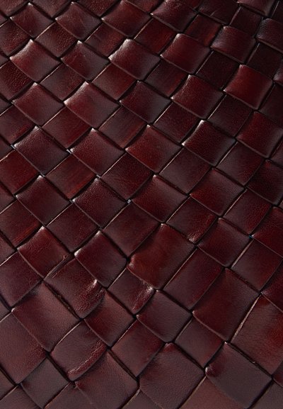 Cuir tissé bordeaux foncé avec un motif carré, présentant une texture lisse et une finition brillante, mettant en valeur des éléments tissés individuels.