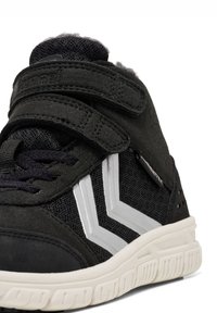 Sort højtop sneakers med et tekstureret stofoverdel, velcro-stropper og hvide detaljer i et chevron mønster. Har en polstret krave og gummisål.