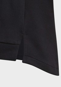 T-shirt in cotone nero con taglio dritto, spacco laterale all'orlo e una texture liscia con cuciture doppie.