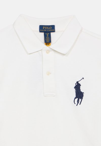 Άσπρο πόλο μπλουζάκι από βαμβάκι με υφή πλέξης, διαθέτει τρία κουμπιά και κεντητό λογότυπο ενός παίκτη πόλο σε ναυτικό μπλε.