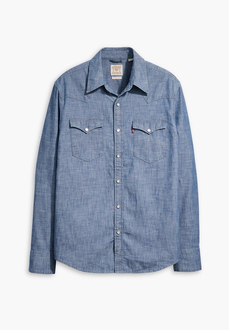 Chemise en denim bleu à manches longues, fermeture boutonnée sur l'avant, col pointu et deux poches poitrine à rabat boutonné.