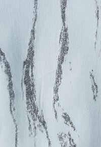 Tissu bleu clair au toucher lisse, avec des stries métalliques argentées dans un motif marbré tout au long.