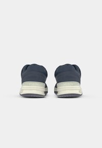 Navy blue athletic shoes with a textured fabric upper, padded collar, and light gray rubber sole featuring horizontal stripes.