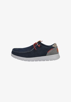 Zapato de ante azul marino con detalles grises, costuras blancas, cordones rojos y suela exterior gris, con un panel trasero texturizado y diseño minimalista.