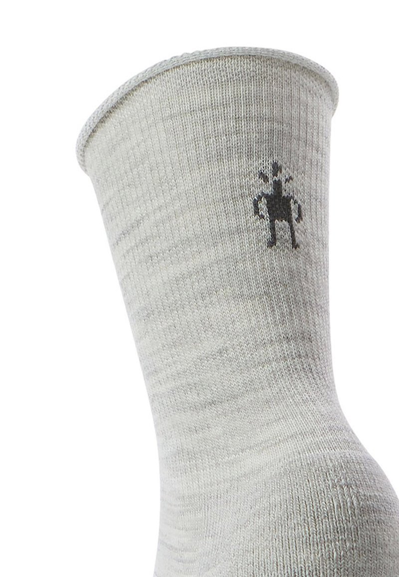 Calzino grigio lavorato a maglia con texture a coste, con un piccolo design grafico nero di una figura vicino alla cima.