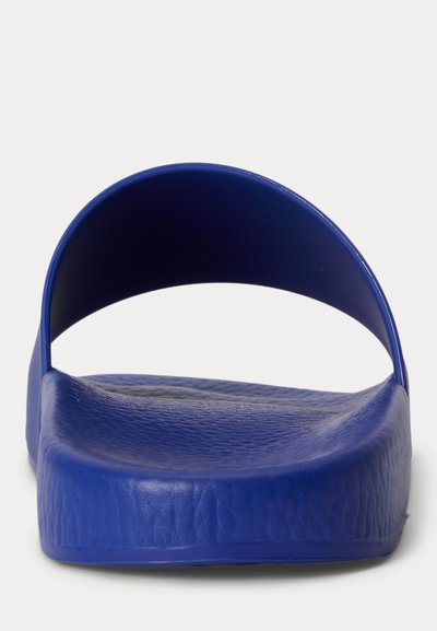 Μπλε σανδάλι slide με υφασμάτινη επιφάνεια πέλματος και φαρδιά λωρίδα, εμφανίζεται από μπροστινή γωνία σε λευκό φόντο.