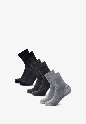 Cinq paires de chaussettes de crew en noir, gris foncé, gris moyen et gris clair. Présentent des textures côtelées variées et des motifs contrastants.