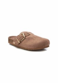 Zapato slip-on de ante marrón con puntera redonda, que presenta un detalle de doble hebilla y una suela texturizada. Diseño simple con acentos mínimos.