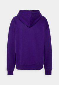 Sudadera con capucha morada que presenta un corte relajado, textura suave, mangas largas y un clásico bolsillo tipo canguro en la parte delantera.