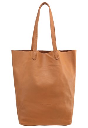 Sac cabas en cuir couleur caramel avec deux longues anses et une surface lisse légèrement texturée, sans décoration sauf un discret marquage en relief près du centre inférieur.