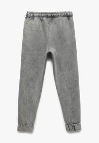 Grå tapered bukser lavet af blødt stof med elastisk talje, opsmøgede nederkanter og en subtil tekstur. Ingen synlige mønstre eller grafikker.