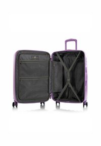 Valise rigide violette avec un intérieur gris. Ses caractéristiques comprennent des poches à double zip, des sangles ajustables et quatre roues pour la mobilité.
