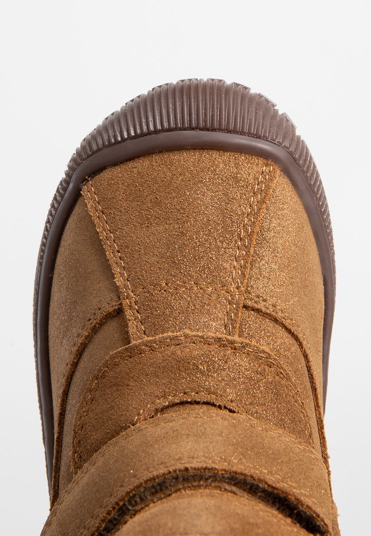 Brauner Wildlederboot mit strukturierter Oberfläche, abgerundeter Zehenpartie und gummierter Sohle mit geriffelten Kanten. Klettverschluss für sicheren Halt.