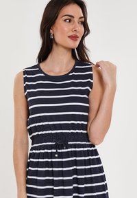 Ärmelloses navyblaues Kleid mit weißen Streifen, elastischem Taillenbund und Schleifendetail. Glattes Baumwollmaterial mit einem lässigen Schnitt und knie-langer Form.