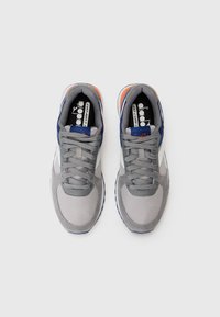 Gray athletic shoes with mesh and suede upper, navy accents, reflective details, and textured sole; laces and logo visible inside.