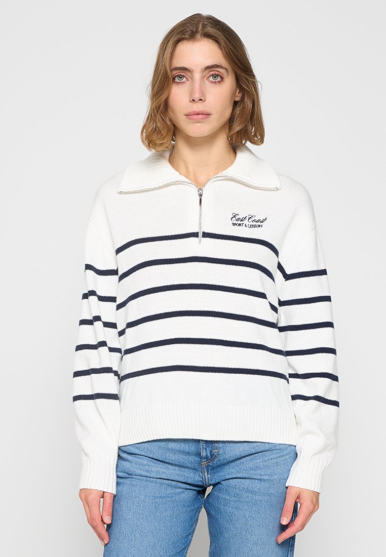 Pulóver de punto blanco con rayas horizontales en navy, cuello con media cremallera y puños acanalados. Presenta el texto "East Coast Sport & Leisure" en el pecho.