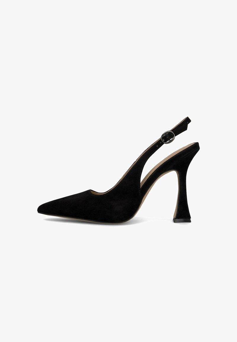 Zapato de tacón de ante negro con punta afilada, un tacón curvado y grueso, y un acento de hebilla circular en la correa ajustable.