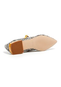Zapato de tacón alto con estampado de cebra, puntera afilada, suela beige y acento dorado en el tacón. Tejido texturizado y diseño estructurado.