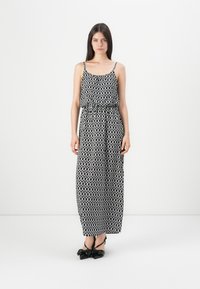 Abito maxi in motivo geometrico bianco e nero, senza maniche con spalline regolabili, vita elasticizzata, tessuto leggero, lunghezza fino al pavimento.
