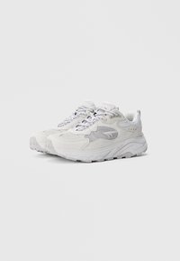 Valged sportlikud tossud, mille pealiskihiks on võrk ja sünteetiline materjal, paks kummist tallaosa ja keerukas paelade disain. Omavad tagasihoidlikku brändingut ja tekstuure.